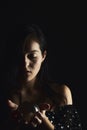 Hispanic teenager playing with a crystal ball on a black background. Mysticism concept Royalty Free Stock Photo