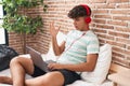 Hispanic teenager using laptop at home sitting on the bedroom celebrating victory with happy smile and winner expression with Royalty Free Stock Photo