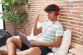 Hispanic teenager using laptop at home sitting on the bedroom screaming proud, celebrating victory and success very excited with Royalty Free Stock Photo