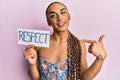 Hispanic transgender man wearing make up and long hair holding respect message pointing finger to one self smiling happy and proud