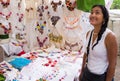 Hispanic woman admiring embroidered Mexican blouses
