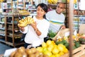 Woman choosing bananas in fruit and vegetable section of supermarket Royalty Free Stock Photo