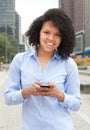 Hispanic woman in the city sending message with phone Royalty Free Stock Photo