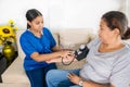 Hispanic woman doctor uses blood pressure check and consults woman patient Royalty Free Stock Photo