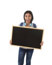 Hispanic woman or female student holding blank blackboard with copy space for adding message Royalty Free Stock Photo