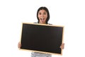 Hispanic woman or female student holding blank blackboard with copy space for adding message Royalty Free Stock Photo