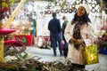 Hispanic woman choosing fir tree decorations at street Christmas fair Royalty Free Stock Photo