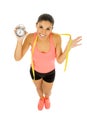 Hispanic woman holding alarm clock and taylor measure tape in time for sport and diet concept Royalty Free Stock Photo