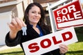 Hispanic Woman Holding Sold Sign and Keys, House Royalty Free Stock Photo