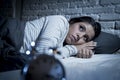 Hispanic woman at home bedroom lying in bed late at night trying to sleep suffering insomnia