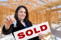 Hispanic Woman With Keys and Sold Sign On Site Inside New Home C Royalty Free Stock Photo