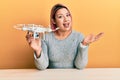 Hispanic woman with pink hair using drone celebrating achievement with happy smile and winner expression with raised hand Royalty Free Stock Photo