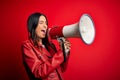 Hispanic woman shouting angry on protest through megaphone Royalty Free Stock Photo