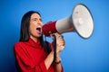 Hispanic woman shouting angry on protest through megaphone Royalty Free Stock Photo