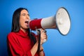 Hispanic woman shouting angry on protest through megaphone Royalty Free Stock Photo