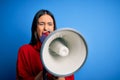 Hispanic woman shouting angry on protest through megaphone Royalty Free Stock Photo