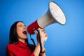 Hispanic woman shouting angry on protest through megaphone Royalty Free Stock Photo
