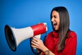 Hispanic woman shouting angry on protest through megaphone Royalty Free Stock Photo