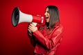 Hispanic woman shouting angry on protest through megaphone Royalty Free Stock Photo