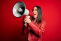 Hispanic woman shouting angry on protest through megaphone Royalty Free Stock Photo