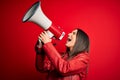 Hispanic woman shouting angry on protest through megaphone Royalty Free Stock Photo