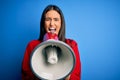 Hispanic woman shouting angry on protest through megaphone Royalty Free Stock Photo