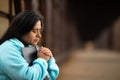 Hispanic Woman Sitting On A Bridge Praying While Holding Bible Royalty Free Stock Photo