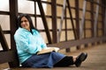 Hispanic Woman Sitting On A Bridge And Reading Bible Royalty Free Stock Photo