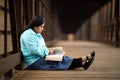Hispanic Woman Sitting On A Bridge And Reading Bible Royalty Free Stock Photo