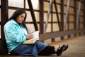 Hispanic Woman Sitting On A Bridge And Reading Bible Royalty Free Stock Photo