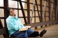 Hispanic Woman Sitting On A Bridge And Reading Bible Royalty Free Stock Photo