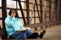 Hispanic Woman Sitting On A Bridge And Reading Bible Royalty Free Stock Photo