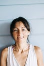 Portrait of hispanic woman with summer dress and ponytail while leaning on wood wall Royalty Free Stock Photo