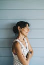 Portrait of hispanic woman with summer dress and ponytail while leaning on wood wall Royalty Free Stock Photo