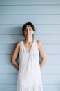 Portrait of hispanic woman with summer dress and ponytail while leaning on wood wall Royalty Free Stock Photo