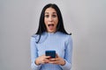 Hispanic woman using smartphone celebrating crazy and amazed for success with open eyes screaming excited Royalty Free Stock Photo