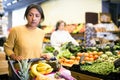 Hispanic woman walking with shopping trolley in grocery shop Royalty Free Stock Photo