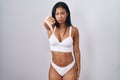 Hispanic woman wearing lingerie looking unhappy and angry showing rejection and negative with thumbs down gesture Royalty Free Stock Photo