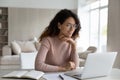 Hispanic woman work on computer online making notes