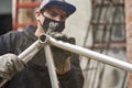 Hispanic worker removing the paint of a bicycle frame at his workshop Royalty Free Stock Photo