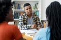 Hispanic young adult talking with african american students