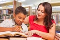 Hispanic Young Boy and Female Adult Studying At Library