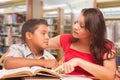 Hispanic Young Boy and Female Adult Studying At Library