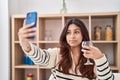 Hispanic young business woman taking a selfie picture drinking a glass of wine relaxed with serious expression on face Royalty Free Stock Photo