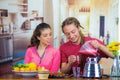 Hispanic young healthy couple enjoying breakfast together, sharing fruits, drinking smoothie and smiling, home kitchen Royalty Free Stock Photo