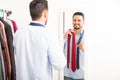 Hispanic young man choosing a tie at home Royalty Free Stock Photo