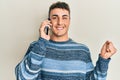 Hispanic young man having conversation talking on the smartphone screaming proud, celebrating victory and success very excited Royalty Free Stock Photo