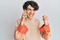 Hispanic young man having conversation talking on the smartphone screaming proud, celebrating victory and success very excited Royalty Free Stock Photo