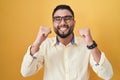 Hispanic young man wearing business clothes and glasses excited for success with arms raised and eyes closed celebrating victory Royalty Free Stock Photo