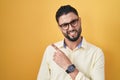 Hispanic young man wearing business clothes and glasses pointing aside worried and nervous with forefinger, concerned and Royalty Free Stock Photo